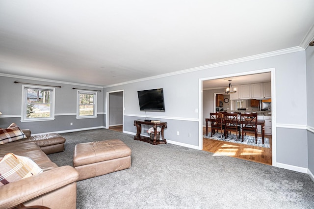 living room with ornamental molding, baseboards, an inviting chandelier, and carpet floors