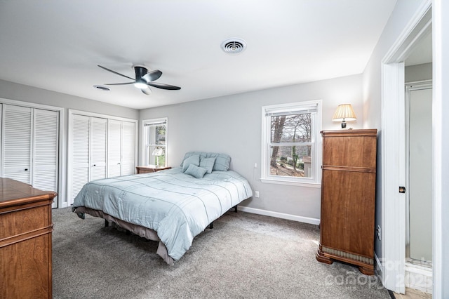 carpeted bedroom with visible vents, multiple closets, baseboards, and ceiling fan