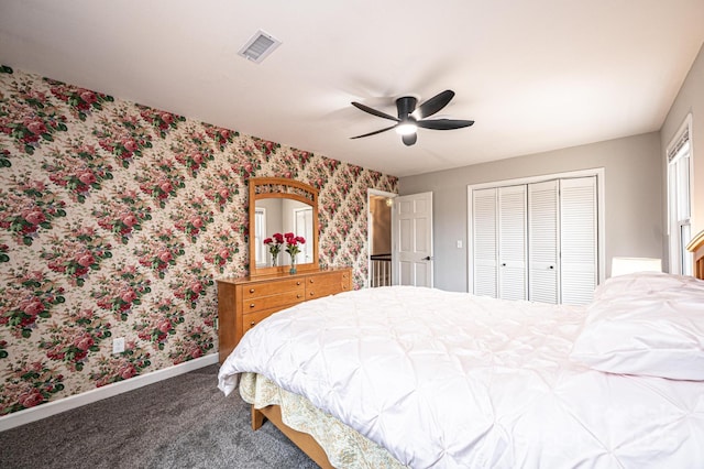 carpeted bedroom with visible vents, wallpapered walls, ceiling fan, baseboards, and a closet