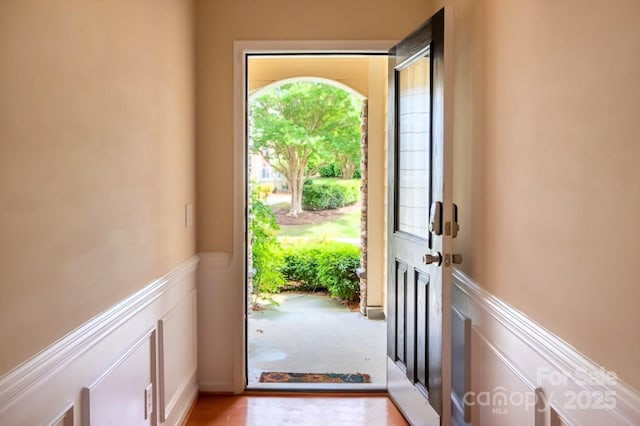doorway featuring a decorative wall and wainscoting
