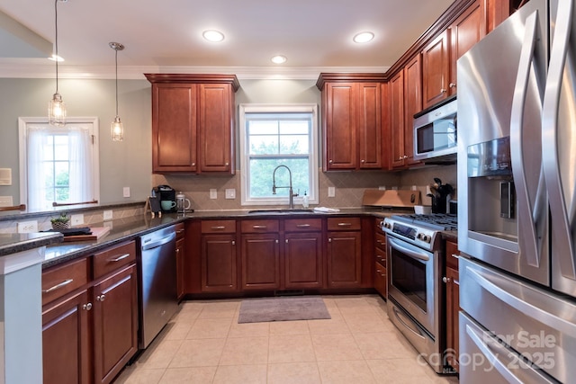 kitchen featuring ornamental molding, a sink, stainless steel appliances, a peninsula, and decorative backsplash