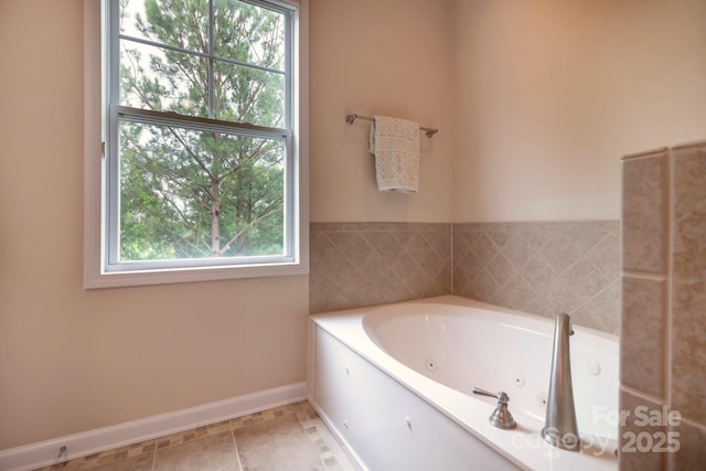 full bathroom with tile patterned flooring, a healthy amount of sunlight, baseboards, and a tub with jets