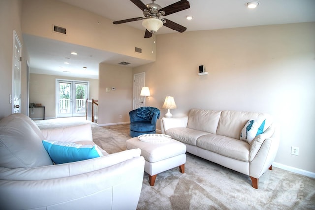 living area with visible vents, baseboards, light colored carpet, vaulted ceiling, and a ceiling fan