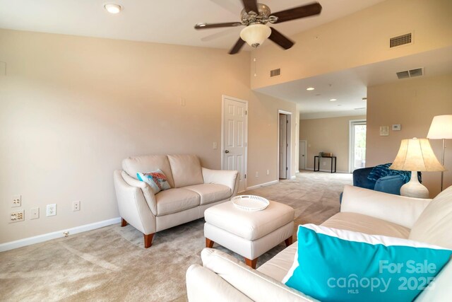 living room featuring light carpet, visible vents, a ceiling fan, and lofted ceiling