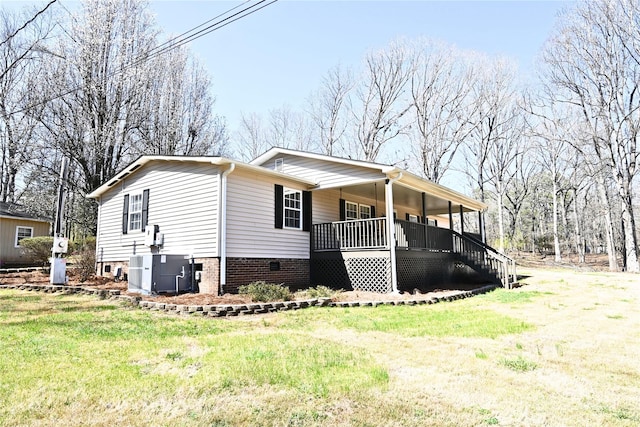 view of front facade featuring a front lawn, cooling unit, and covered porch