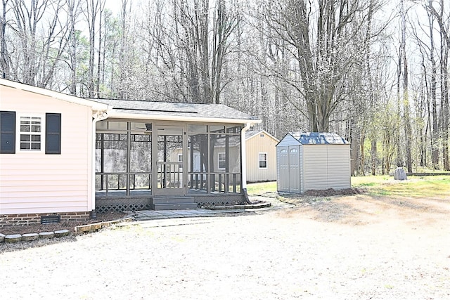 exterior space featuring crawl space, a shed, an outdoor structure, and a sunroom