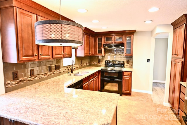 kitchen with light stone countertops, a sink, black appliances, glass insert cabinets, and tasteful backsplash