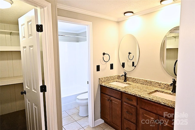 bathroom with tile patterned flooring, double vanity, toilet, and a sink