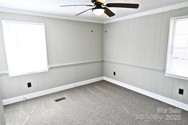 unfurnished room with visible vents, carpet floors, ceiling fan, and ornamental molding