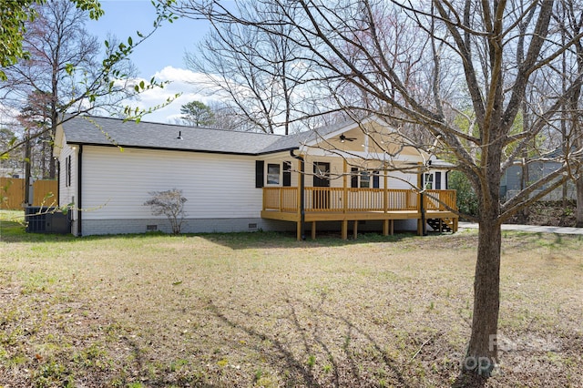 back of property with a shingled roof, central air condition unit, a wooden deck, a yard, and crawl space