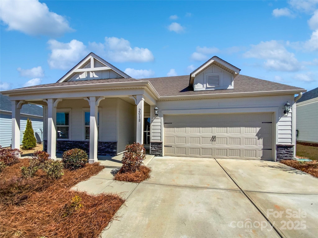 2018 Hyacinth Ct, Denver, NC 28037 - view of front facade with stone siding, driveway, a garage, and roof with shingles