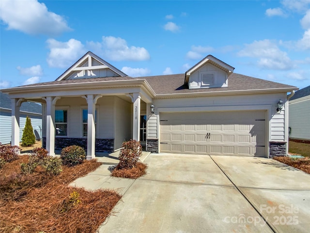 view of front of home featuring concrete driveway, an attached garage, and stone siding