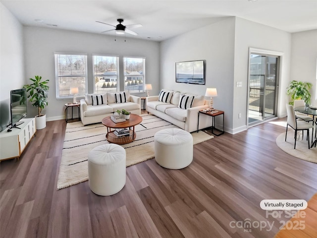 living room featuring wood finished floors, baseboards, and ceiling fan