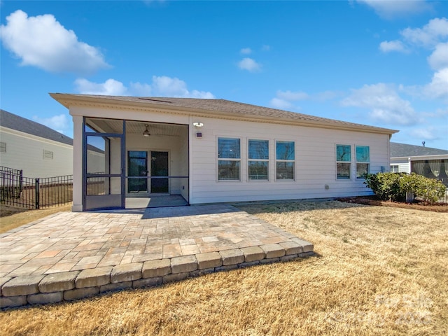 back of house featuring a patio area, fence, a sunroom, and a lawn