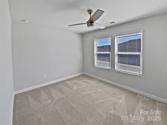 carpeted empty room featuring a ceiling fan and baseboards