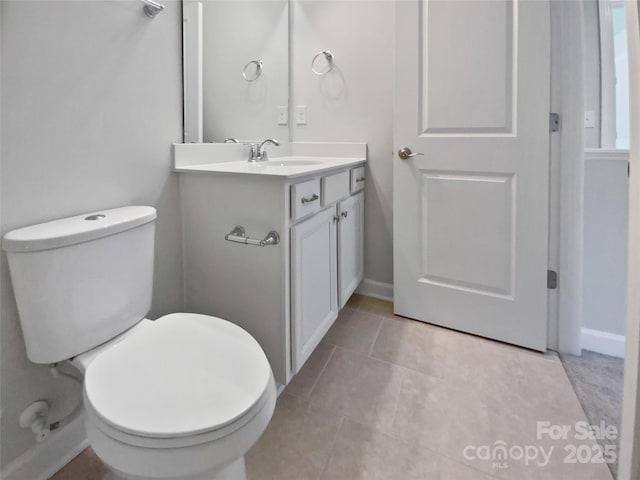 bathroom with tile patterned floors, toilet, vanity, and baseboards