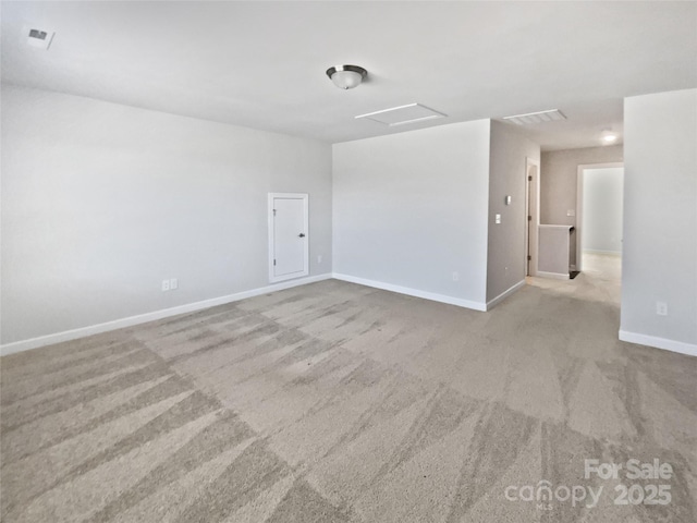 unfurnished room featuring baseboards, visible vents, attic access, and carpet