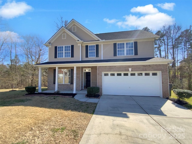 traditional-style house featuring brick siding, a front lawn, concrete driveway, covered porch, and an attached garage