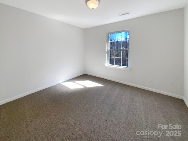 unfurnished room with baseboards, visible vents, and carpet floors