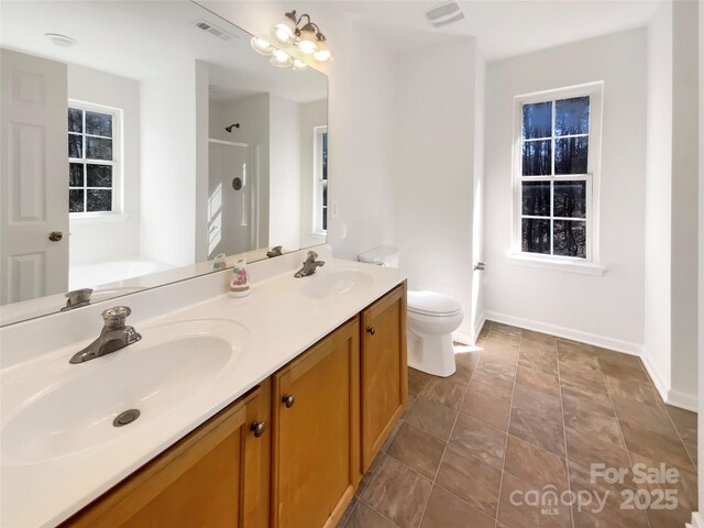 full bath featuring double vanity, toilet, visible vents, and a sink