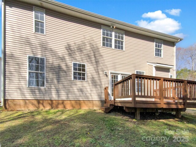 rear view of property featuring a lawn and a wooden deck