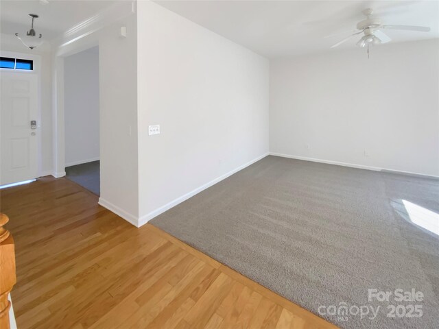 empty room featuring a ceiling fan, wood finished floors, and baseboards