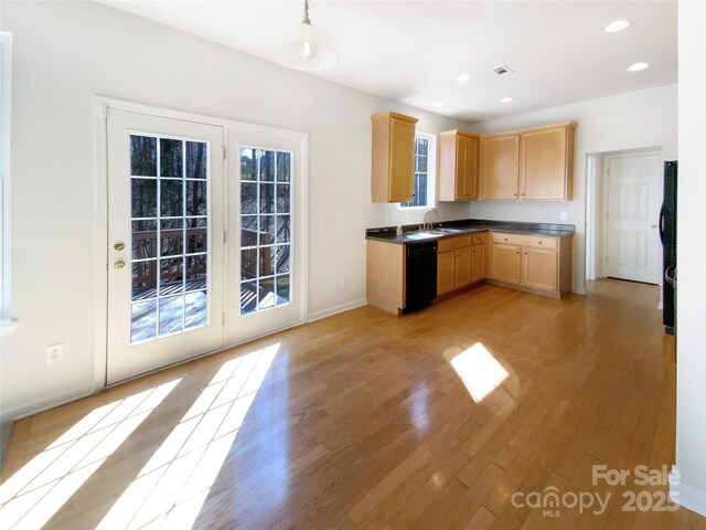 kitchen with a sink, black dishwasher, light brown cabinets, and light wood finished floors