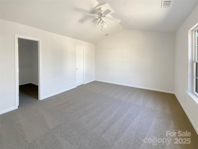 empty room with a ceiling fan, visible vents, baseboards, lofted ceiling, and carpet flooring