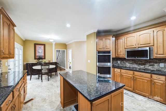 kitchen featuring visible vents, a kitchen island, crown molding, decorative backsplash, and stainless steel appliances