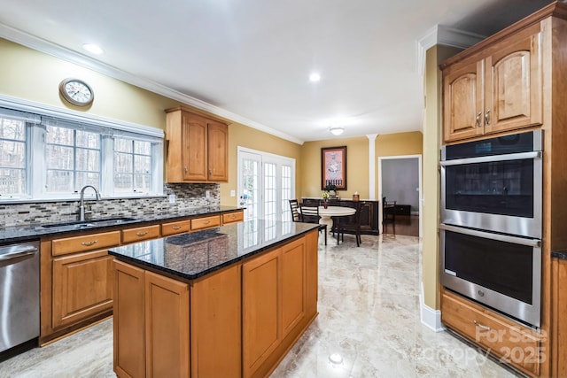 kitchen featuring a sink, dark stone countertops, backsplash, stainless steel appliances, and crown molding