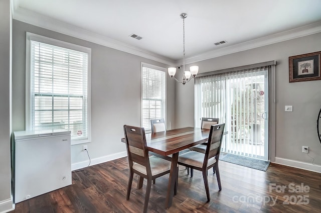 dining room featuring a wealth of natural light, visible vents, dark wood-type flooring, and a chandelier