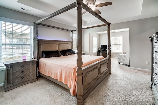 bedroom featuring baseboards, visible vents, ceiling fan, light carpet, and a raised ceiling