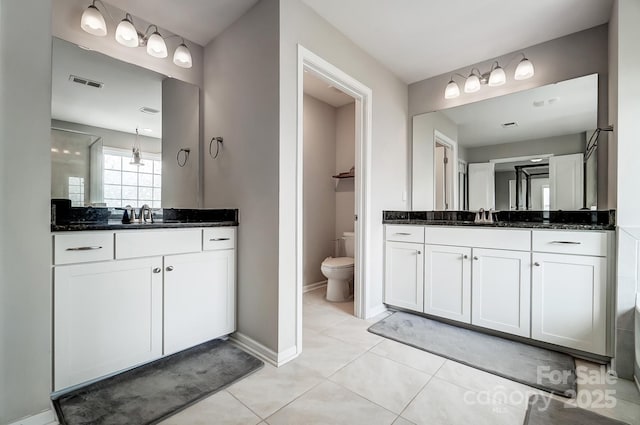 bathroom with a sink, visible vents, toilet, and two vanities