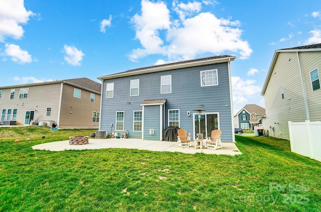 rear view of house featuring a patio area, fence, a fire pit, and a lawn