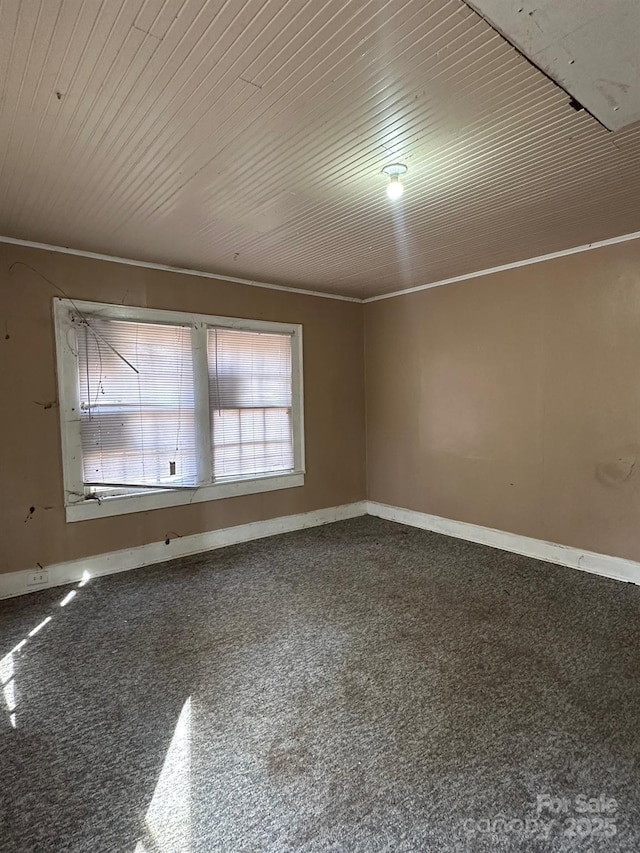 unfurnished room with baseboards, carpet floors, and wooden ceiling