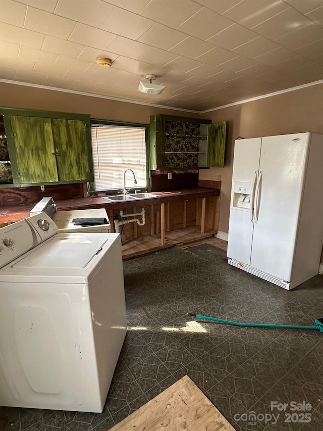 washroom featuring washer and dryer, a sink, crown molding, dark floors, and laundry area