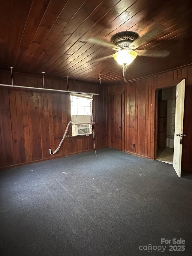 empty room with wooden ceiling, cooling unit, wood walls, and ceiling fan