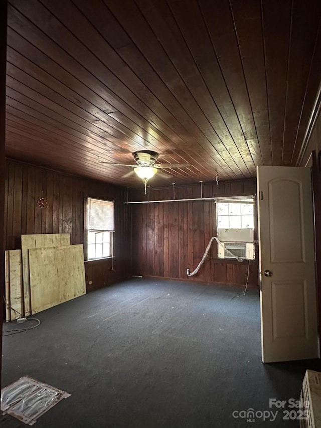 empty room with wood walls, cooling unit, wood ceiling, and a ceiling fan