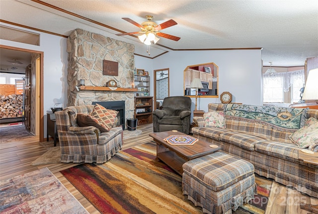 living area with a textured ceiling, crown molding, a ceiling fan, and wood finished floors