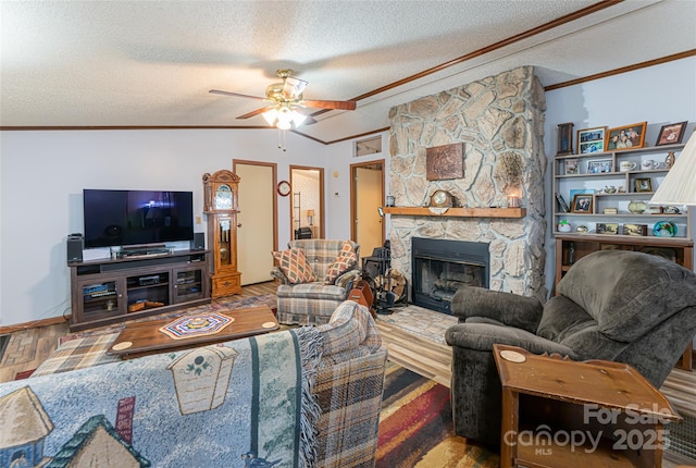 living area with ceiling fan, vaulted ceiling, ornamental molding, a stone fireplace, and wood finished floors