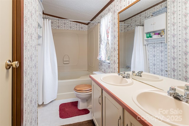 bathroom with a sink, a textured ceiling, and wallpapered walls