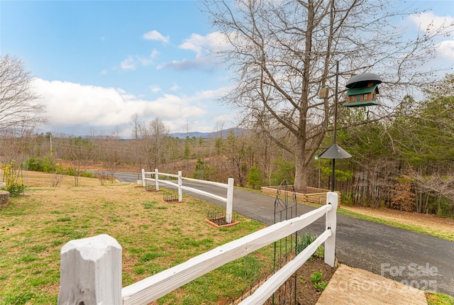 view of yard featuring fence and a mountain view