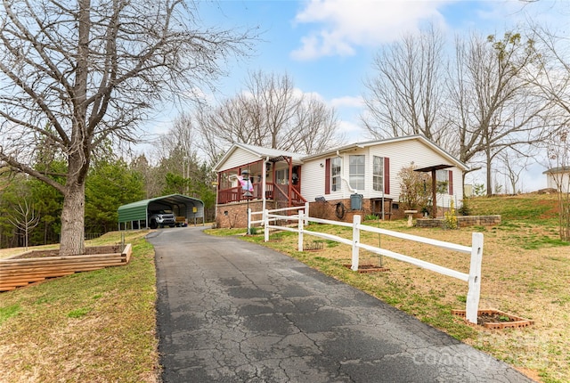 bungalow featuring a front yard, a carport, driveway, and fence