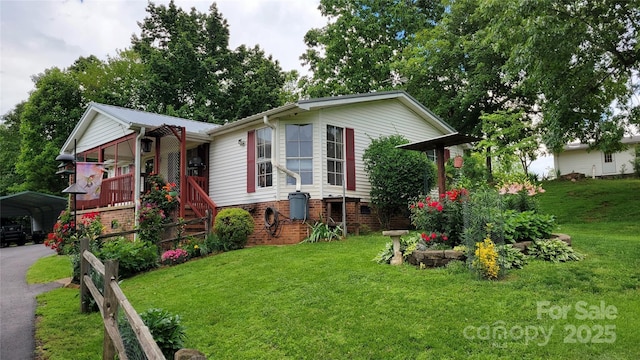 view of front of property featuring driveway, a carport, and a front lawn