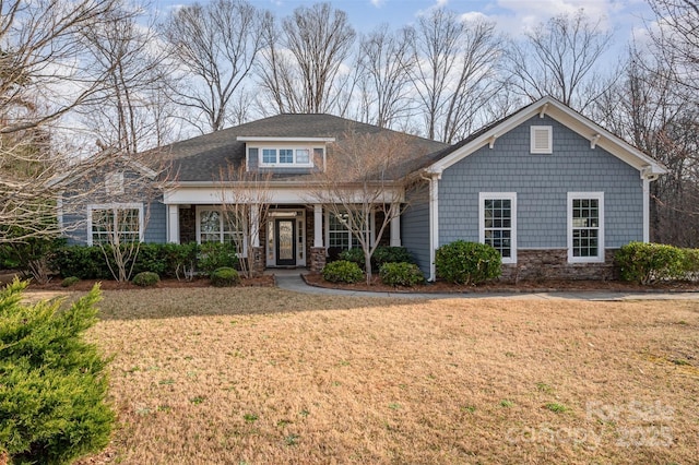 view of front facade with stone siding and a front yard