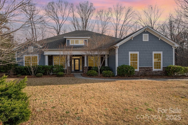 view of front of house featuring a front lawn and stone siding