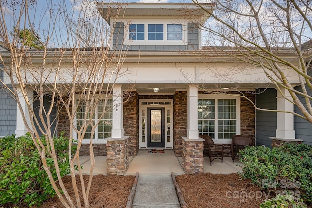 property entrance featuring a porch and stone siding