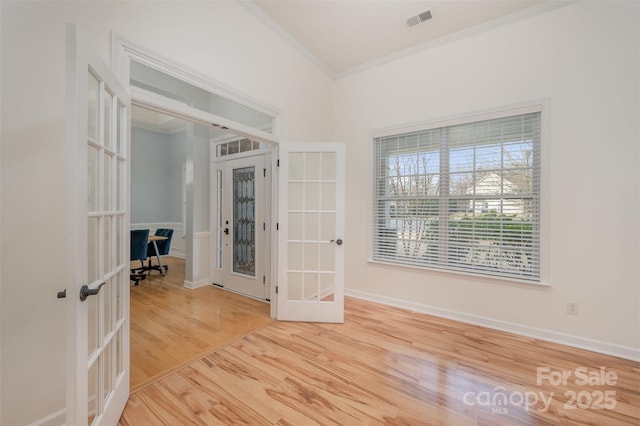 spare room with visible vents, crown molding, baseboards, french doors, and wood finished floors