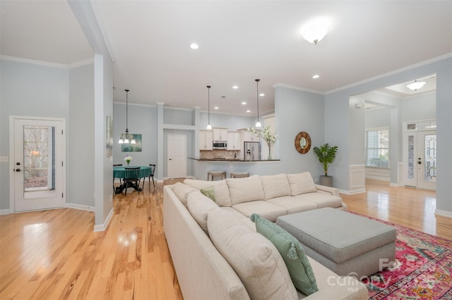 living area with crown molding and light wood finished floors