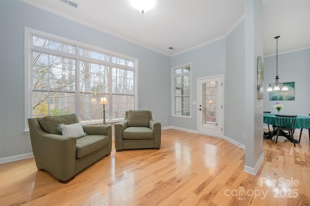 sitting room with baseboards, a notable chandelier, ornamental molding, and light wood finished floors